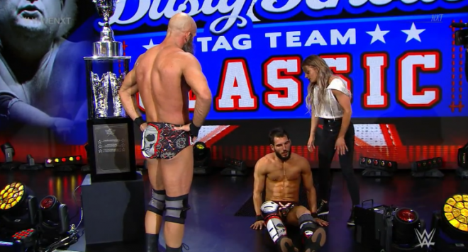 On stage, next to the Dusty Classic trophy, Ciampa and LeRae look on at Johnny Gargano, sitting down with an injured left knee.