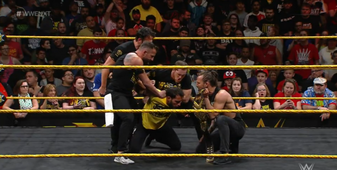 Cole is intimidating Gargano in the ring after Strong surprise attacked him. He, O'Reilly & Fish hold Gargano up by the arms to listen to Cole.