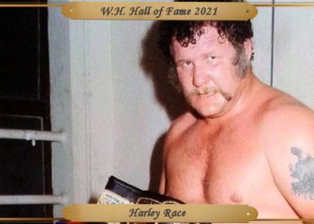 Race with his trademark sideburns and moustache, stares at the camera after a match, holding the NWA crown title.