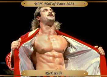 Rude poses in the ring, showcasing his well-formed pecs and abs.