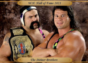 Wearing their 1993-era WWE neon and black singlets, Rick, on left in his traditional wrestling headpiece and Scott with his long hair pose for the camera.