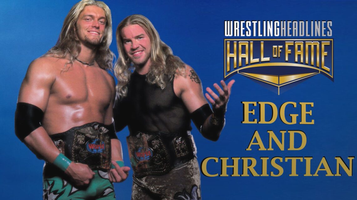 Edge, at left, with blonde shoulder-length hair, wears a WWF World Tag Team Championship belt around his waist with green trunks. Christian, at right, with slightly longer than shoulder length blonde hair, wears a mesh tank top, tag team belt around his waist and tope coloured trunks.
