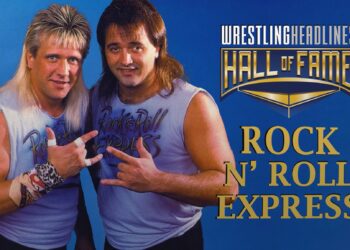 Gibson & Morton stand in light blue tank tops, flexing their fingers in the rock and roll sign pose at their chests.