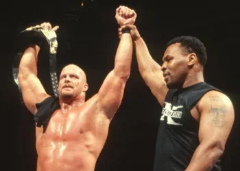 "Iron" Mike Tyson Raises "Stone Cold" Steve Austin's Hand In Victory After Austin Wins The WWF Championship At WrestleMania 14 | Source: WWE.com
