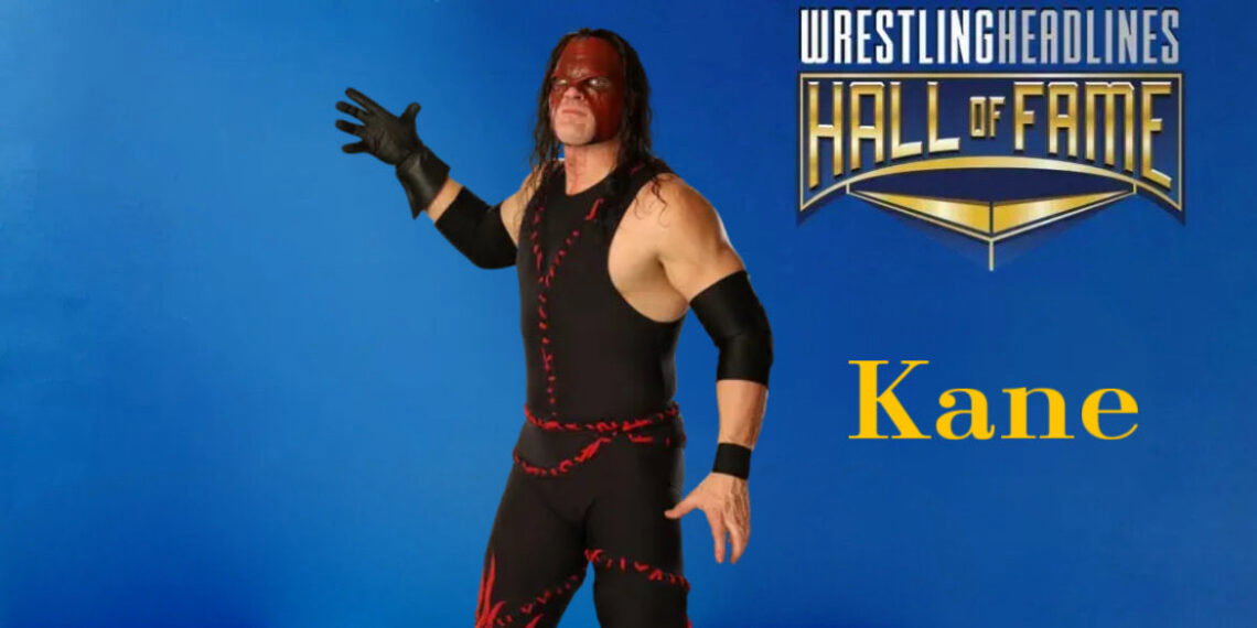 Kane, wearing his more recent red and black demon mask that does not cover his mouth, is standing with his right, black-gloved hand stretched out ready to chokeslam his opponent. He is wearing his mostly black spandex one-piece suit with the red stitching on it.