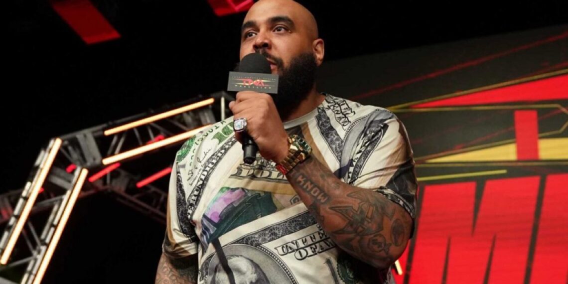 AJ Francis speaks into a microphone at a TNA Wrestling event