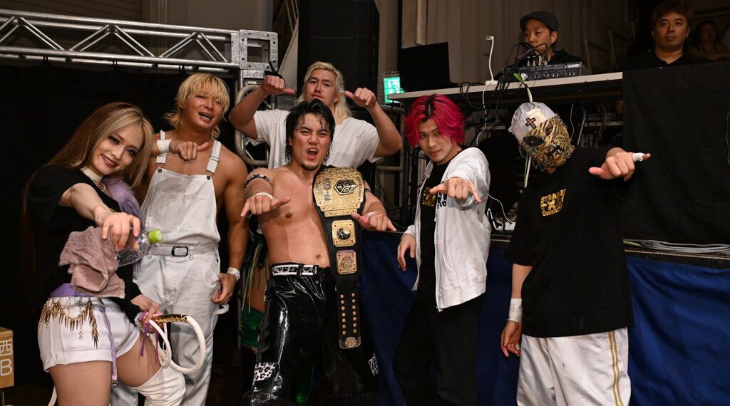 MAO holds a DDT championship belt with fellow wrestlers after a show
