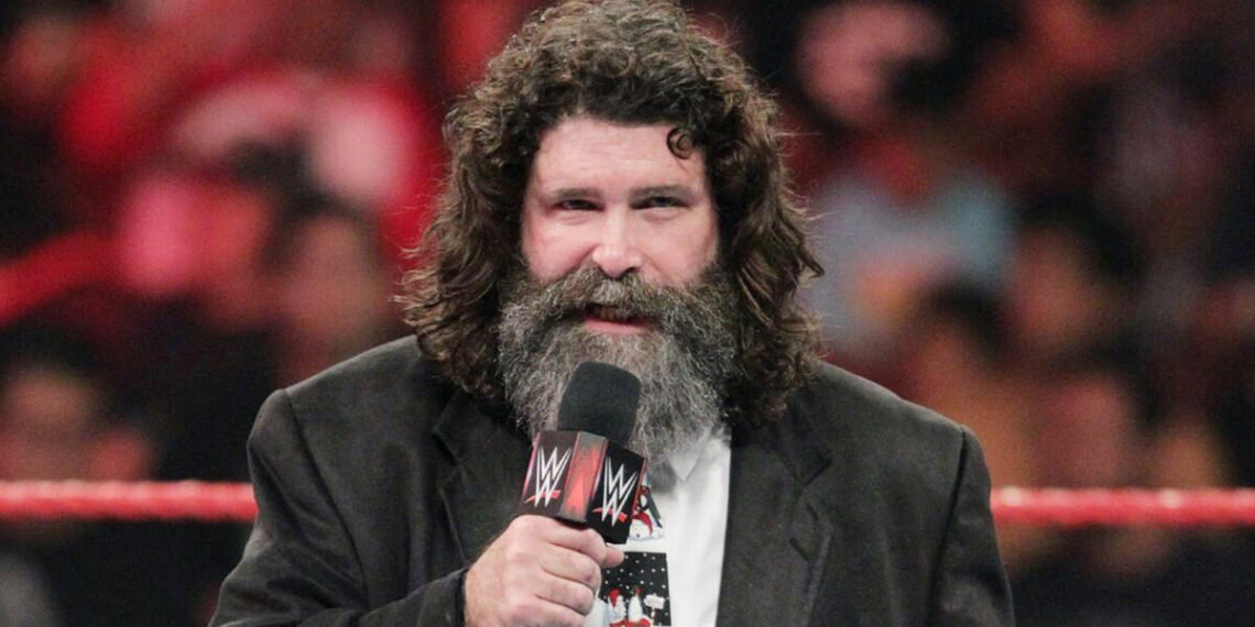 Mick Foley speaks to a WWE crowd with a microphone