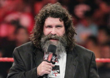 Mick Foley speaks to a WWE crowd with a microphone