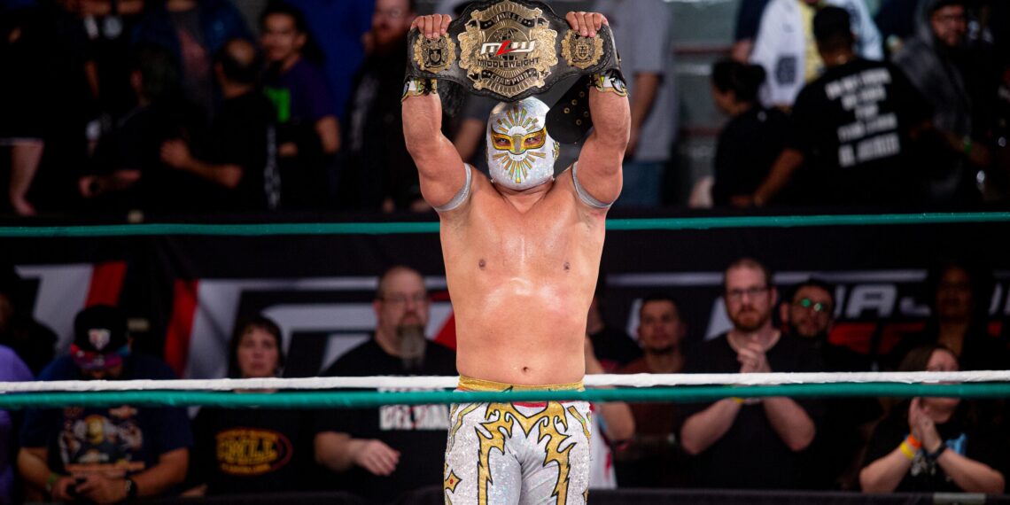 MĂstico holds the MLW World Middleweight Championship in the ring
