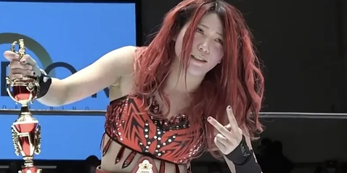 Utami Hayashishita holds a trophy inside a wrestling ring
